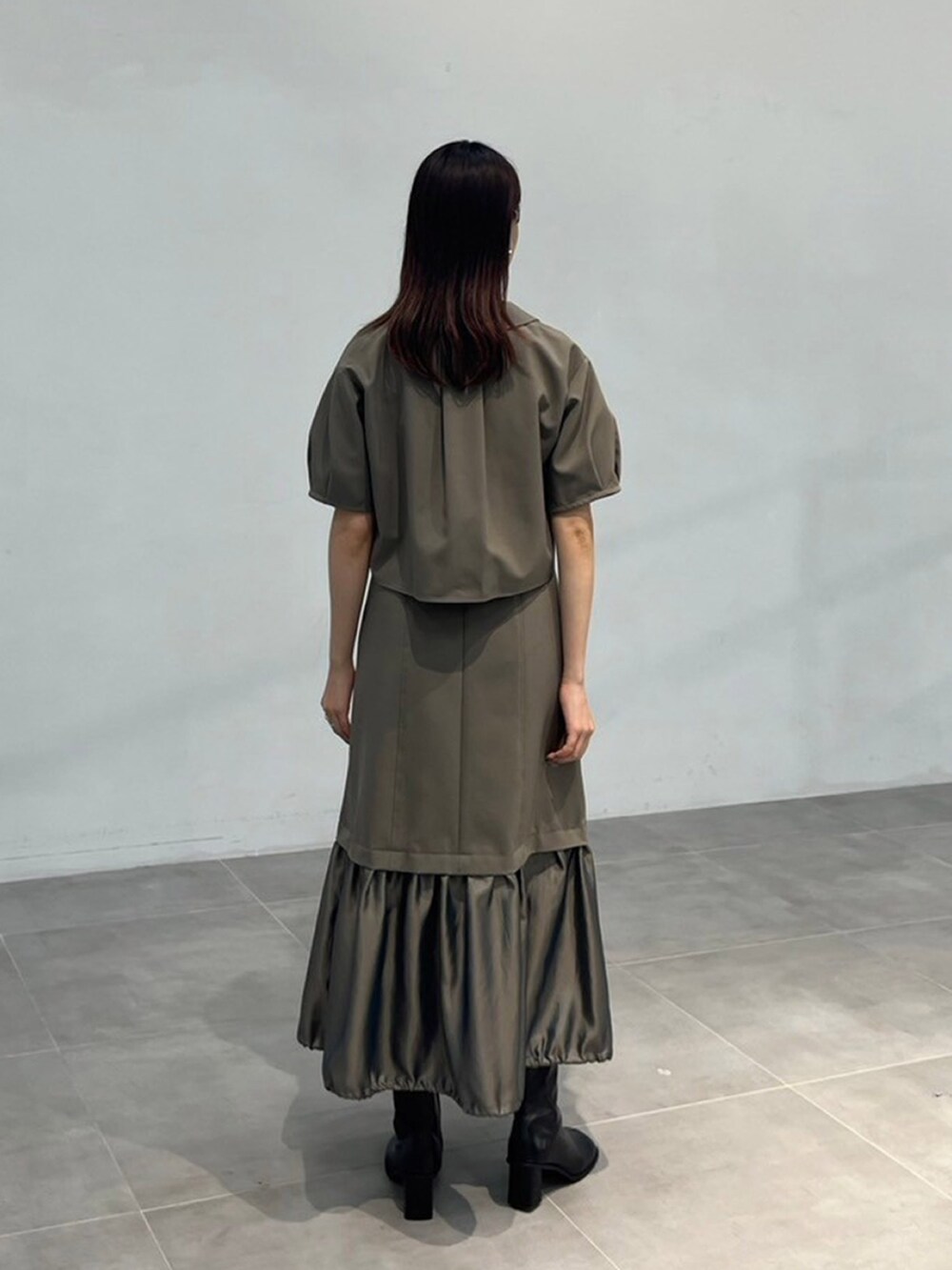 グリーン系のワンピースを着用したレディースの秋コーディネートの3枚目の写真