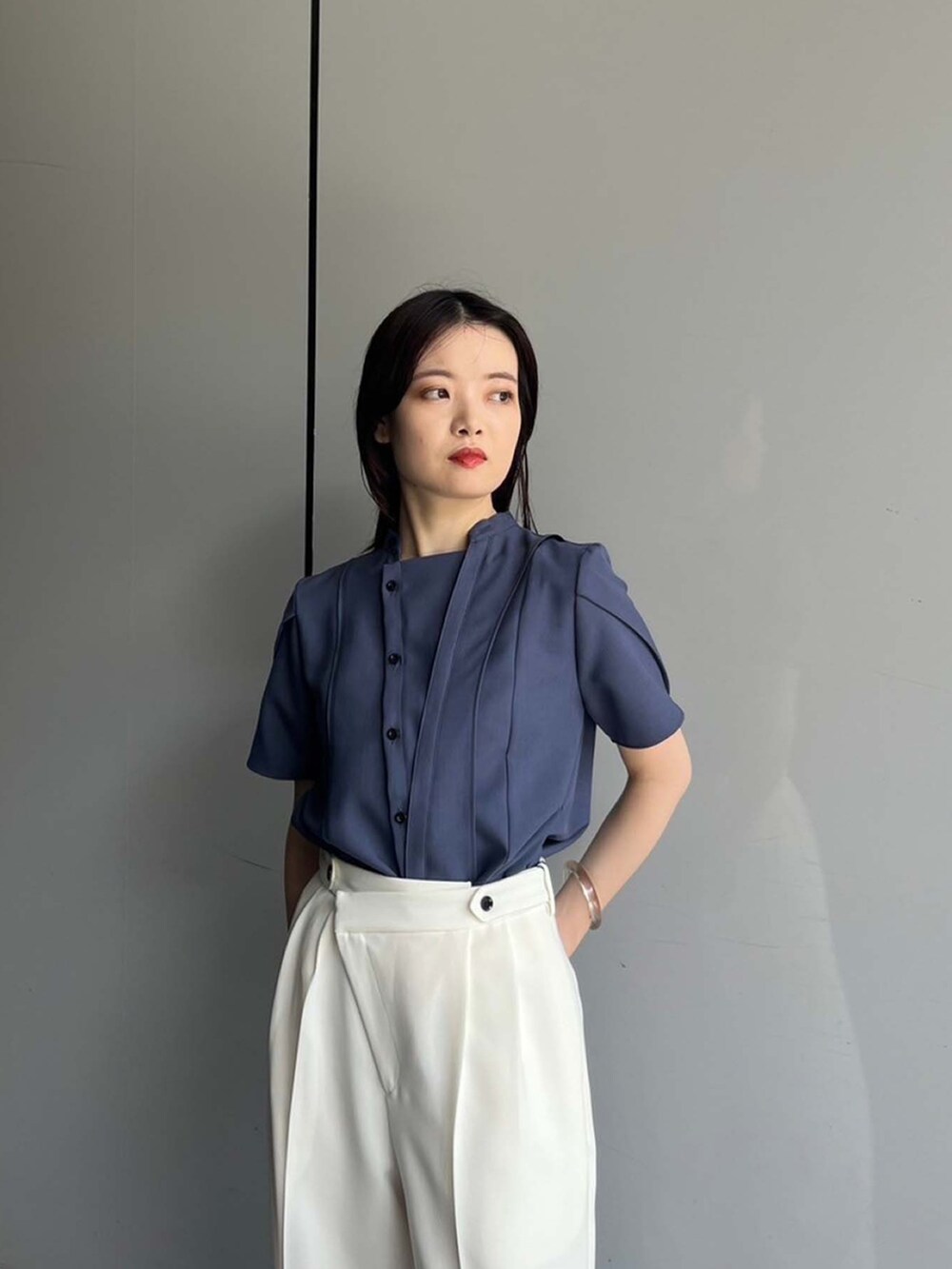 ブルー系のシャツ/ブラウス、ホワイト系のスラックスを着用したレディースの夏コーディネートの3枚目の写真