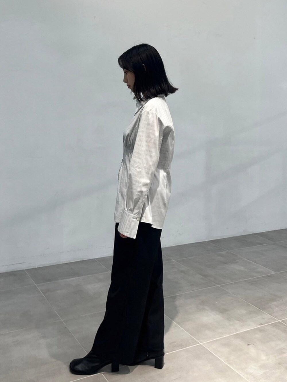 グレー系のシャツ/ブラウス、ブラック系のスラックスを着用したレディースの秋コーディネートの2枚目の写真