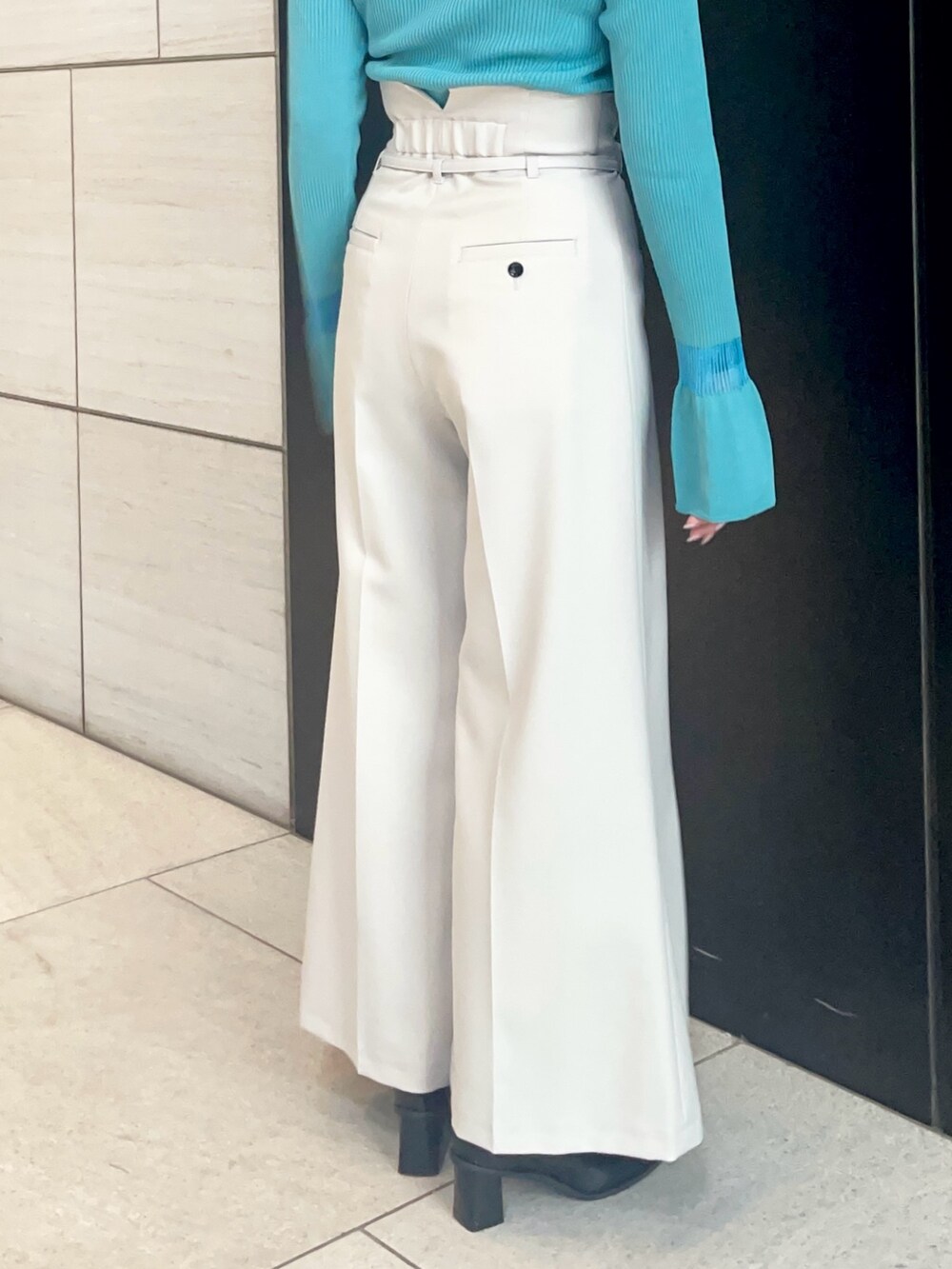 グレー系のスラックス、ブルー系のニット/セーターを着用したレディースの春コーディネートの6枚目の写真