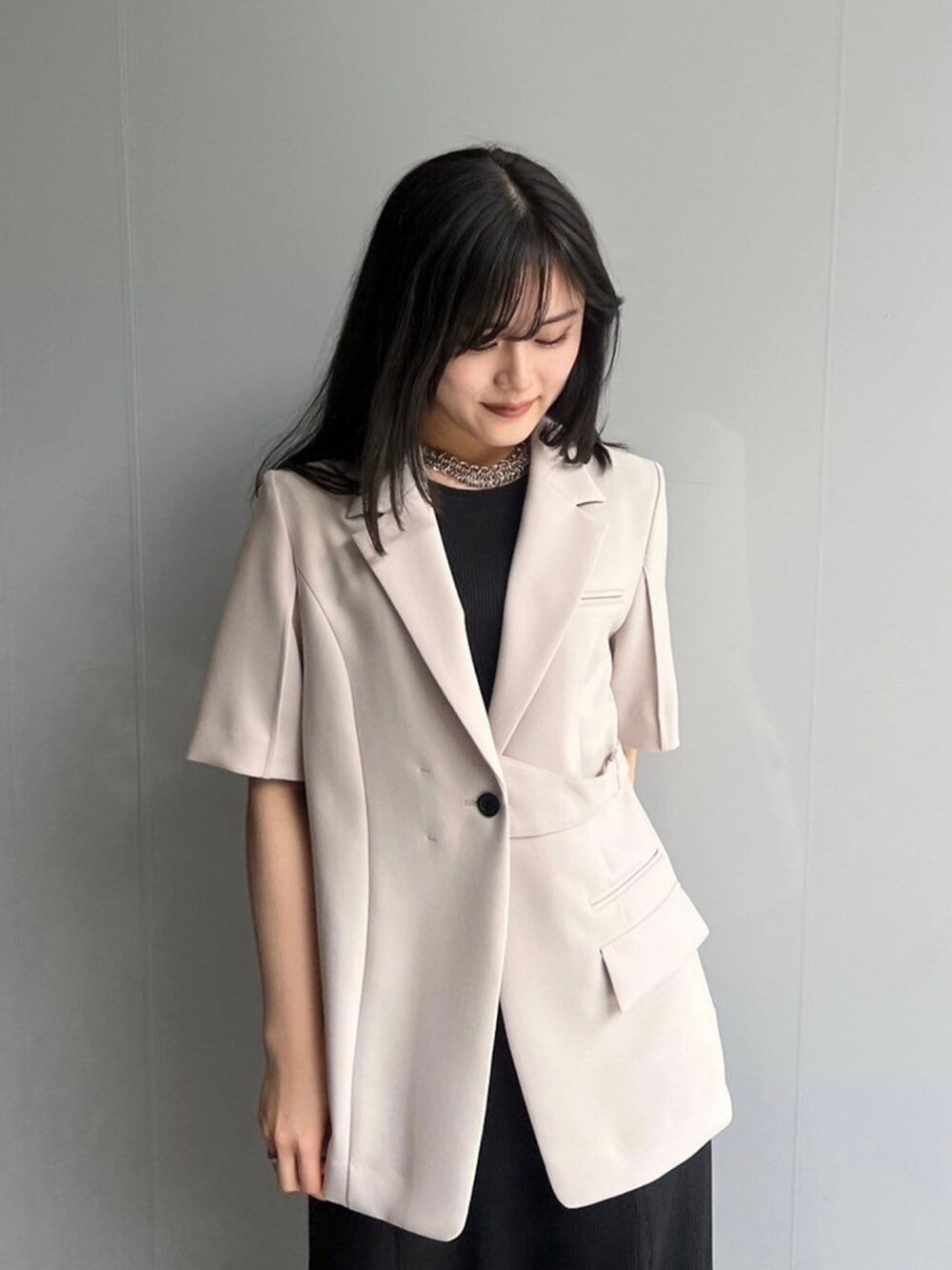 ベージュ系のテーラードジャケット、ブラック系のワンピースを着用したレディースの春コーディネートの5枚目の写真