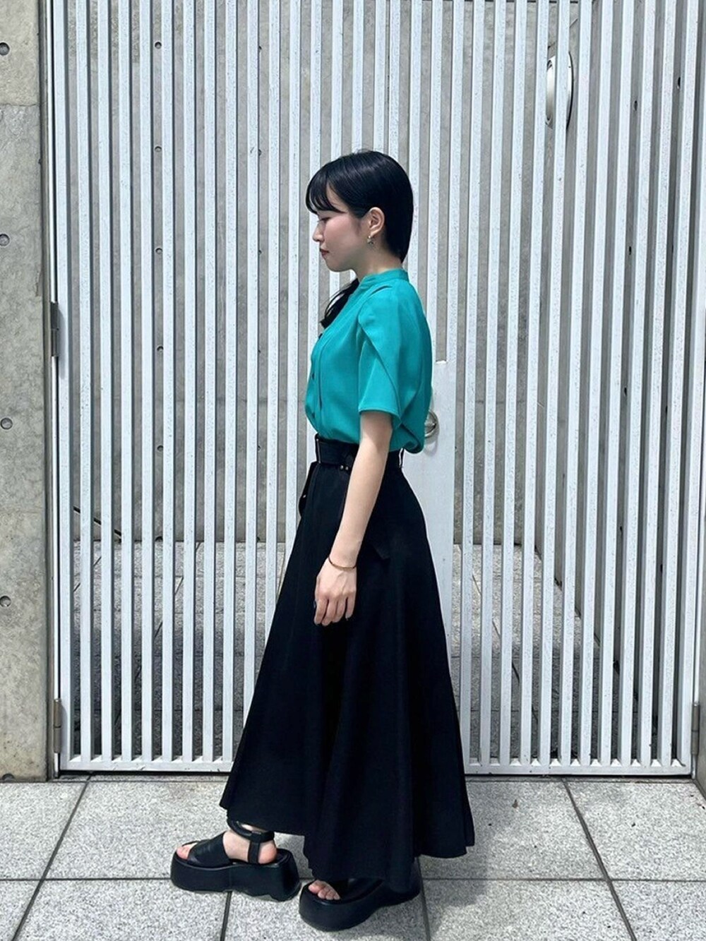 グリーン系のシャツ/ブラウス、ブラック系のスカートを着用したレディースの春コーディネートの2枚目の写真