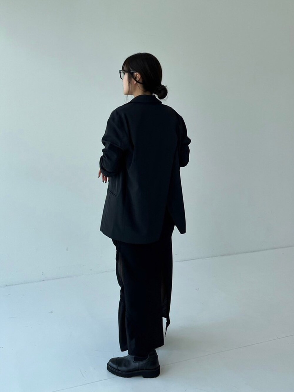 ブラック系のスカート、ブラック系のテーラードジャケット、ブラウン系のTシャツ/カットソーを着用したレディースの秋コーディネートの3枚目の写真