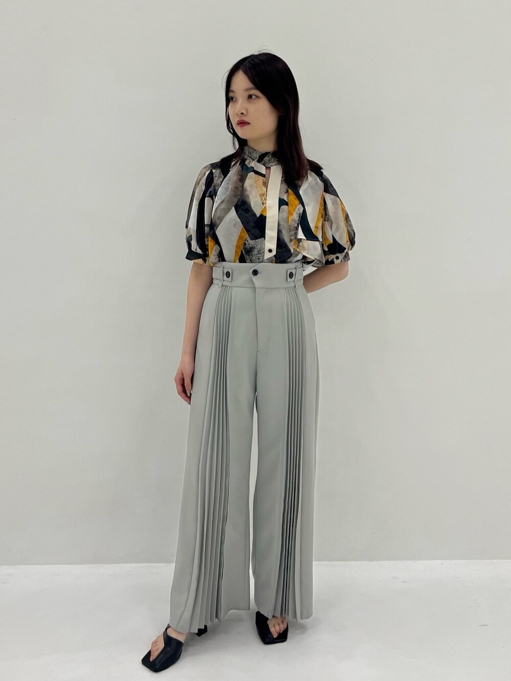 イエロー系のシャツ/ブラウス、グレー系のその他パンツを着用したレディースの春コーディネートの2枚目の写真