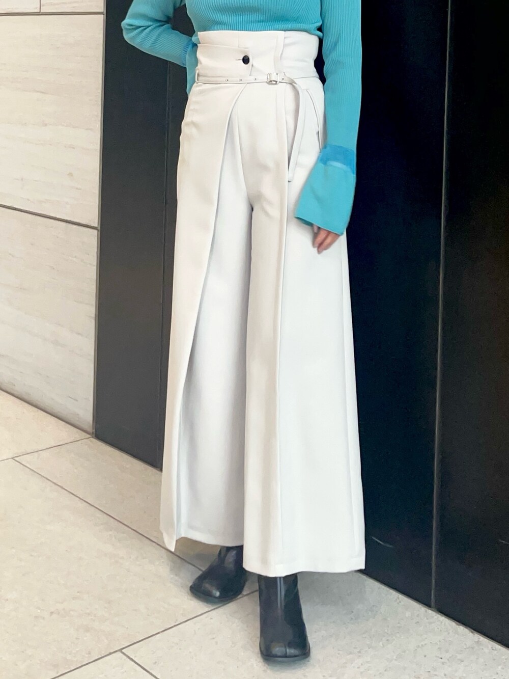 グレー系のスラックス、ブルー系のニット/セーターを着用したレディースの春コーディネートの5枚目の写真