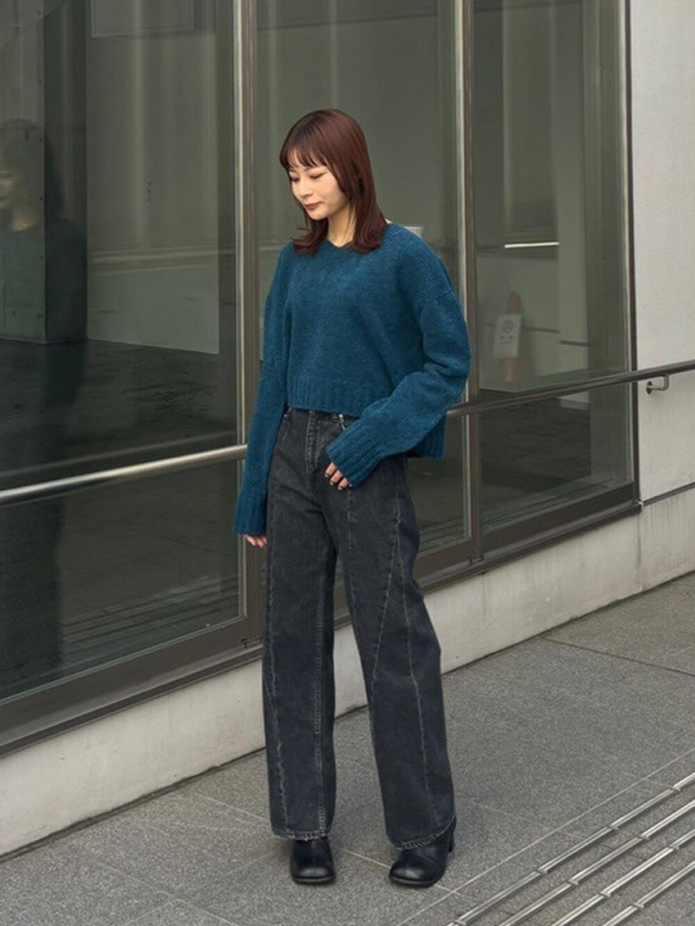 ブルー系のニット/セーター、ブラック系のデニムパンツを着用したレディースの秋コーディネートの2枚目の写真