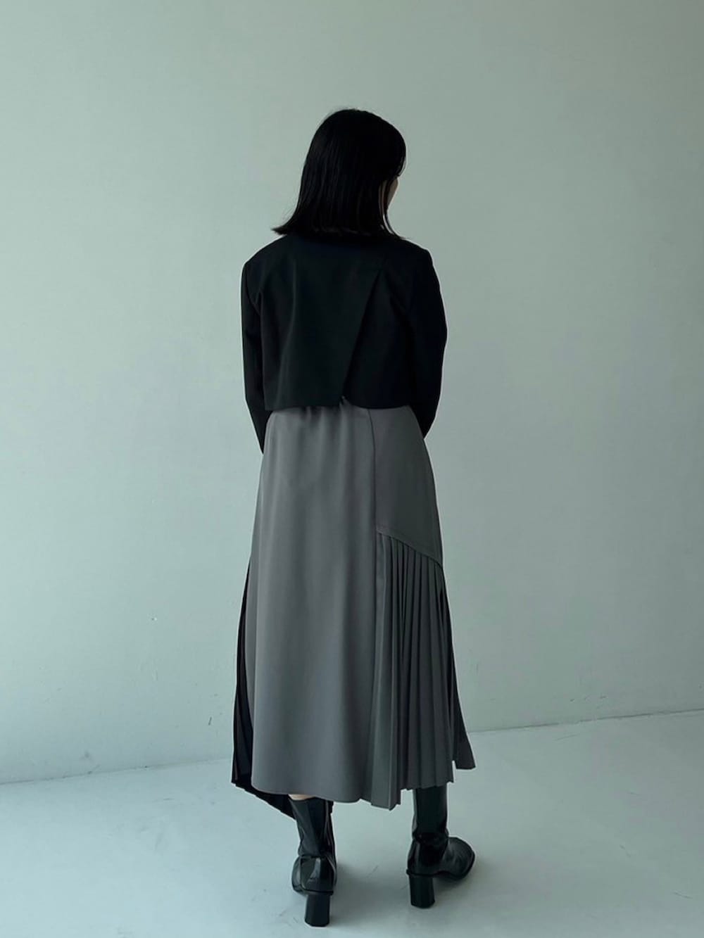 ブラック系のテーラードジャケット、グリーン系のスカートを着用したレディースの秋コーディネートの3枚目の写真