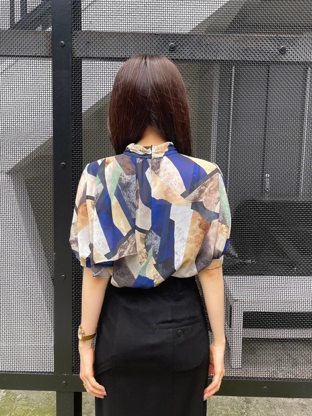 ブルー系のシャツ/ブラウス、ブラック系のスカートを着用したレディースの春コーディネートの6枚目の写真