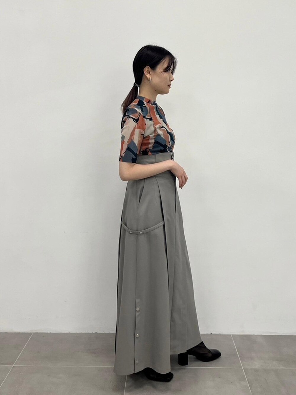 ベージュ系のTシャツ/カットソー、グレー系のスカートを着用したレディースの春コーディネートの4枚目の写真