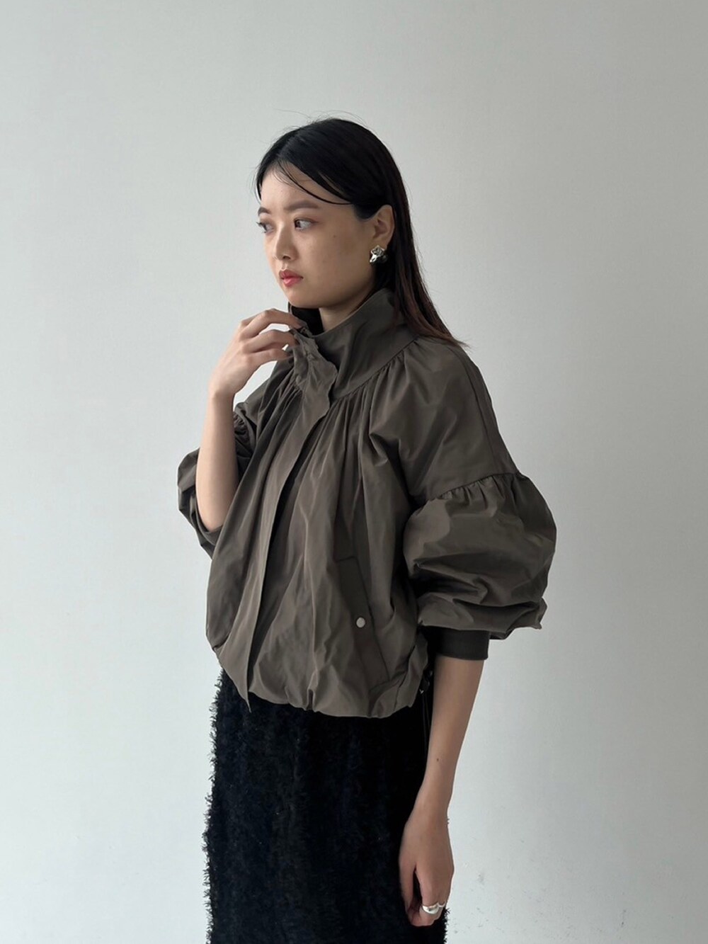 ブラウン系のブルゾン、ブラック系のスカートを着用したレディースの秋コーディネートの4枚目の写真