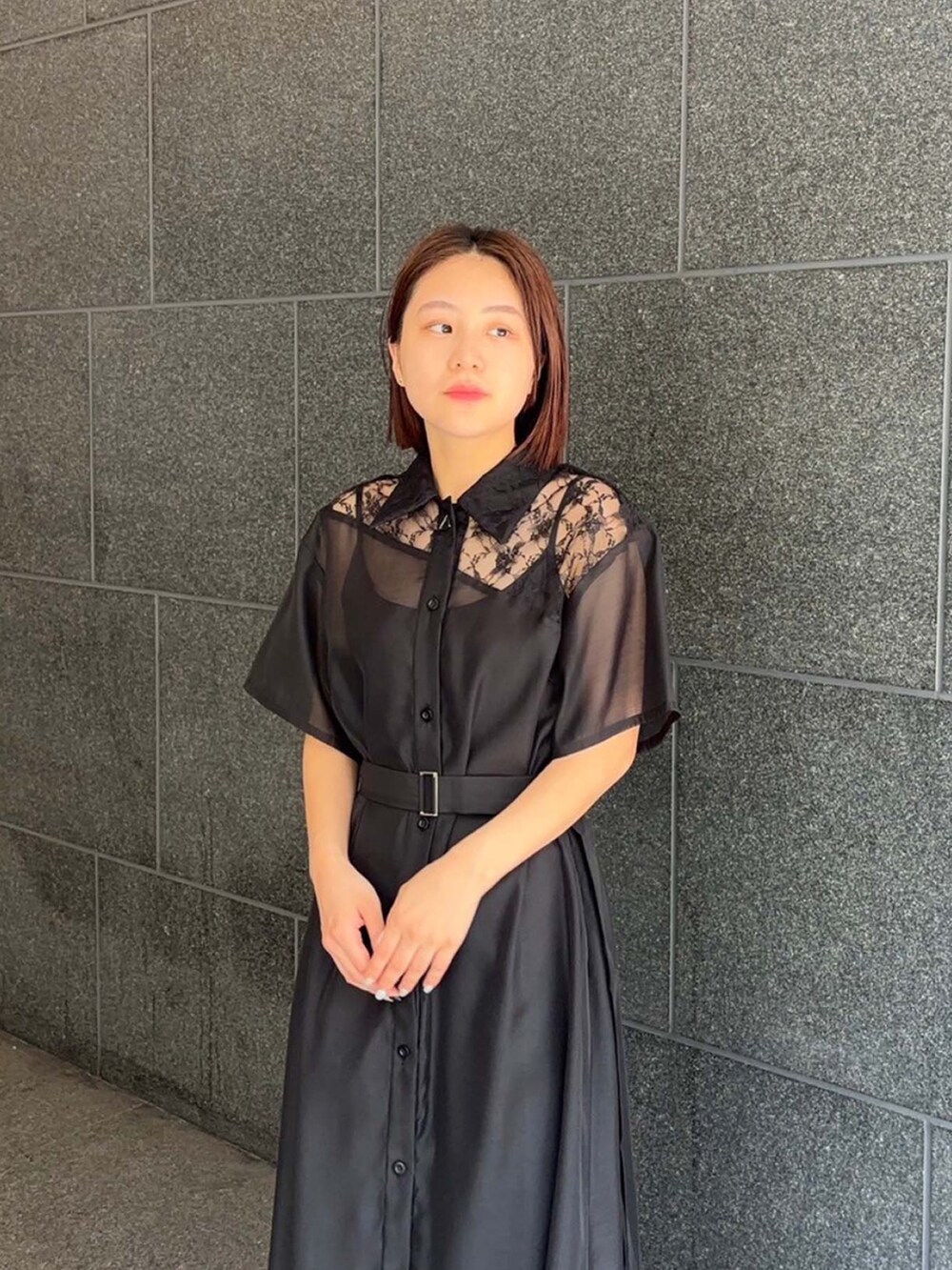 ブラック系のシャツワンピースを着用したレディースの夏コーディネートの4枚目の写真