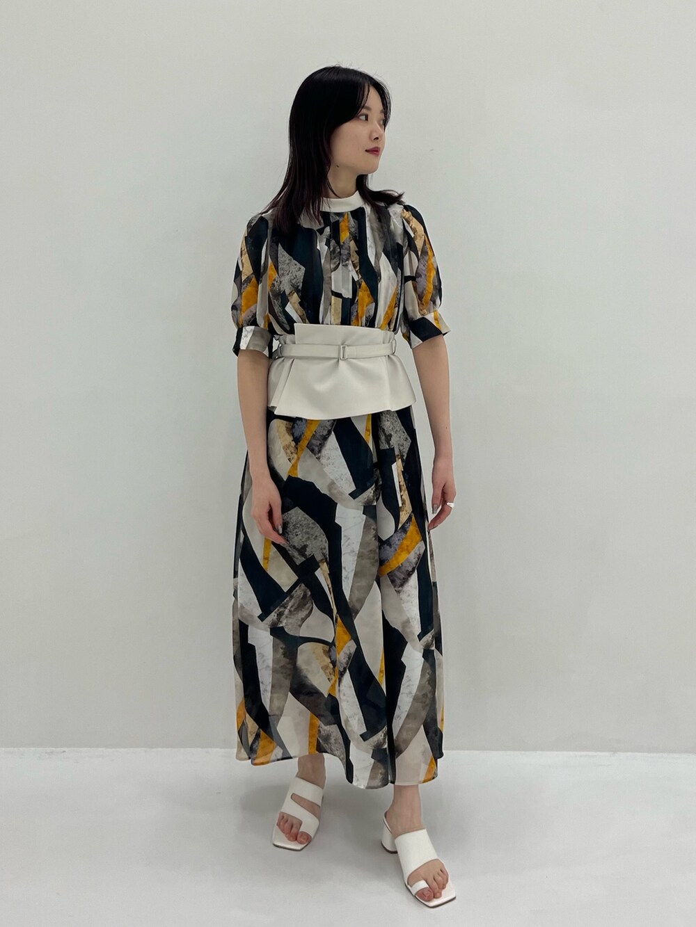 イエロー系のワンピースを着用したレディースの春コーディネートの2枚目の写真