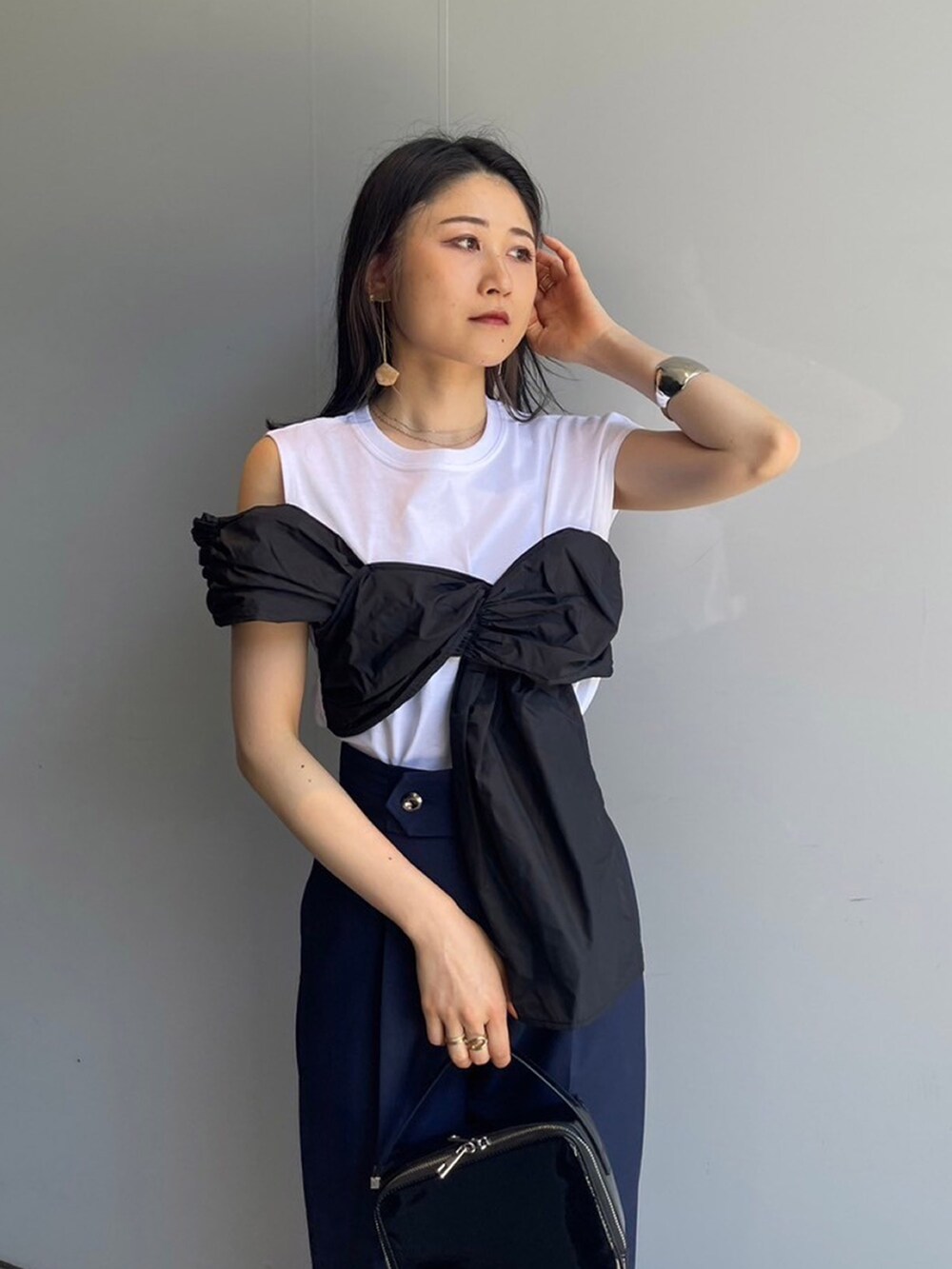 ホワイト系のTシャツ/カットソー、ブルー系のスラックスを着用したレディースの夏コーディネートの3枚目の写真