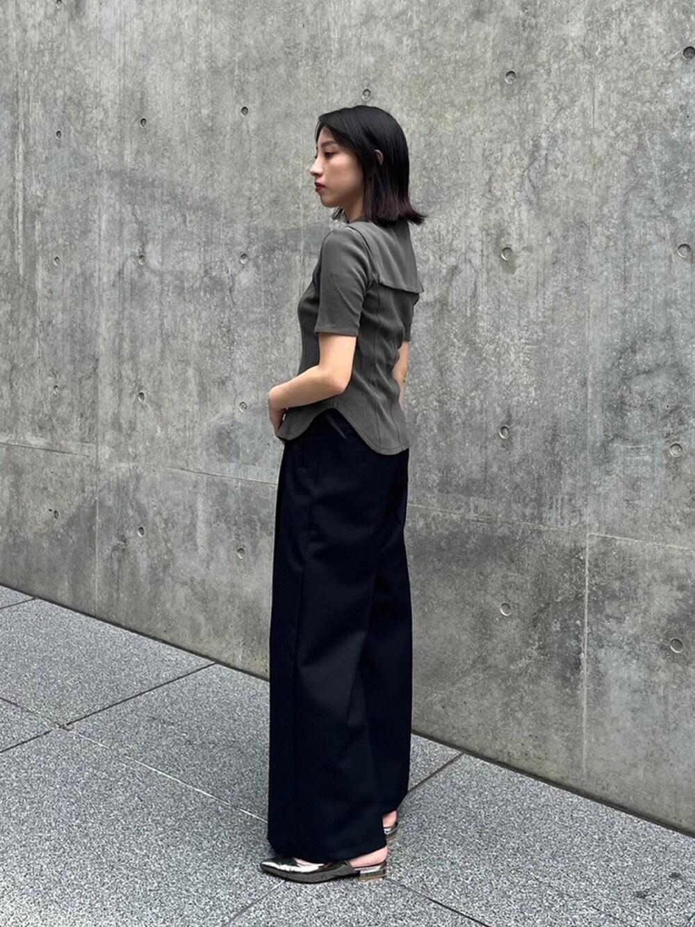 グリーン系のTシャツ/カットソー、ブラック系のスラックスを着用したレディースの夏コーディネートの2枚目の写真
