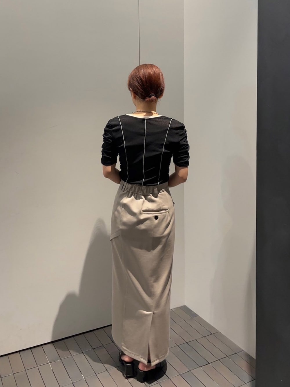 ブラック系のTシャツ/カットソー、ベージュ系のスカートを着用したレディースの夏コーディネートの3枚目の写真