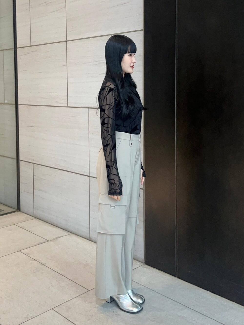 ベージュ系のカーゴパンツ、ブラック系のTシャツ/カットソーを着用したレディースの春コーディネートの4枚目の写真