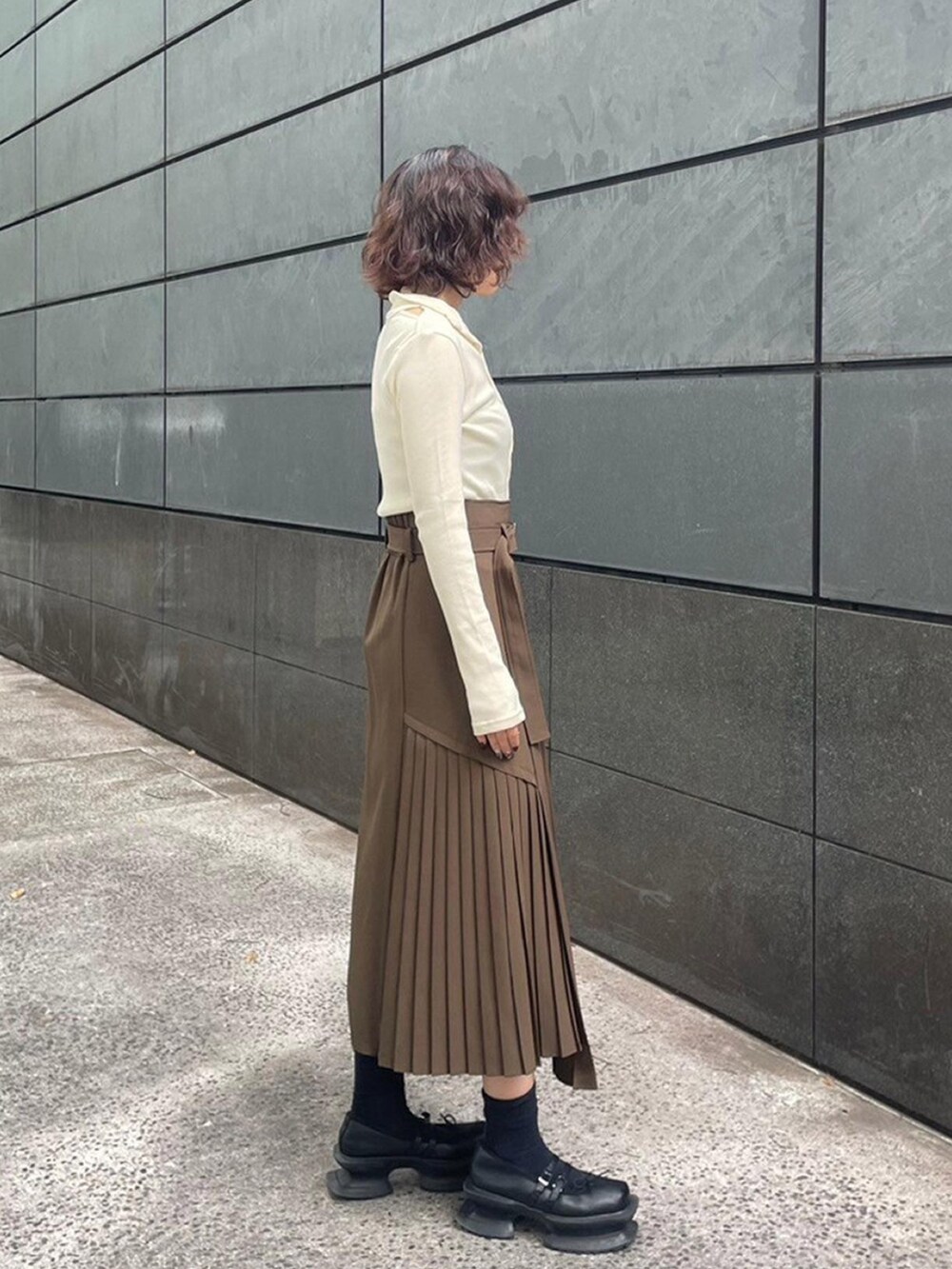 ホワイト系のTシャツ/カットソー、ブラウン系のスカートを着用したレディースの秋コーディネートの2枚目の写真