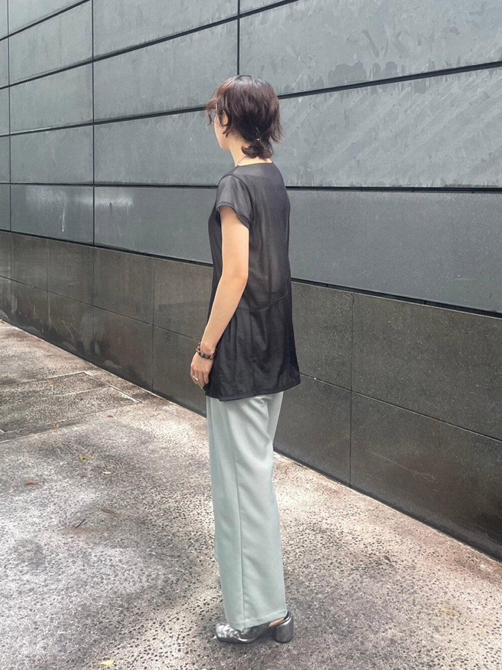 ブラック系のTシャツ/カットソー、グリーン系のスラックスを着用したレディースの夏コーディネートの2枚目の写真