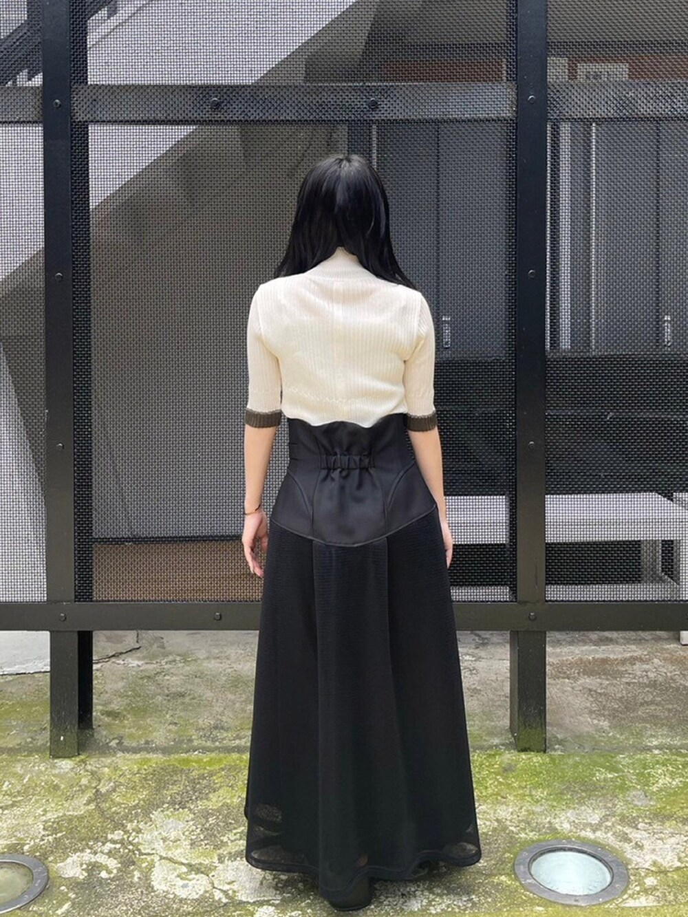 ブラック系のスカート、ホワイト系のニット/セーターを着用したレディースの春コーディネートの3枚目の写真