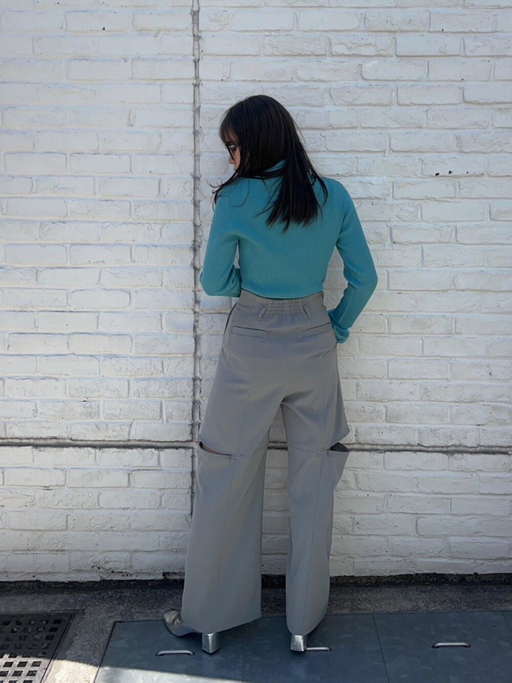 ブルー系のニット/セーター、グレー系のその他パンツを着用したレディースの春コーディネートの3枚目の写真