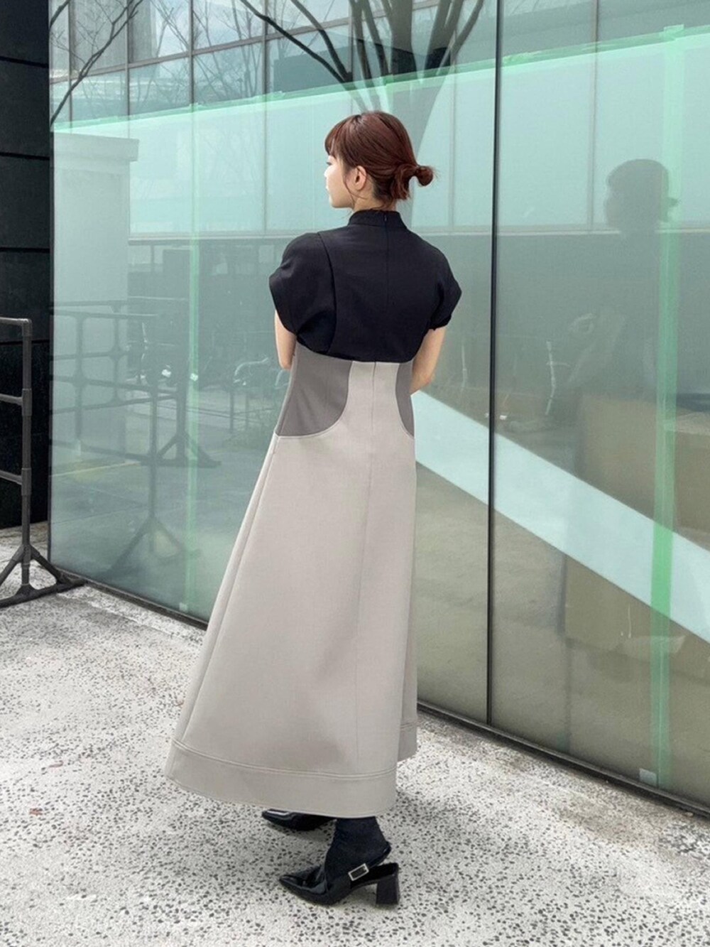 ブラック系のワンピースを着用したレディースの春コーディネートの2枚目の写真