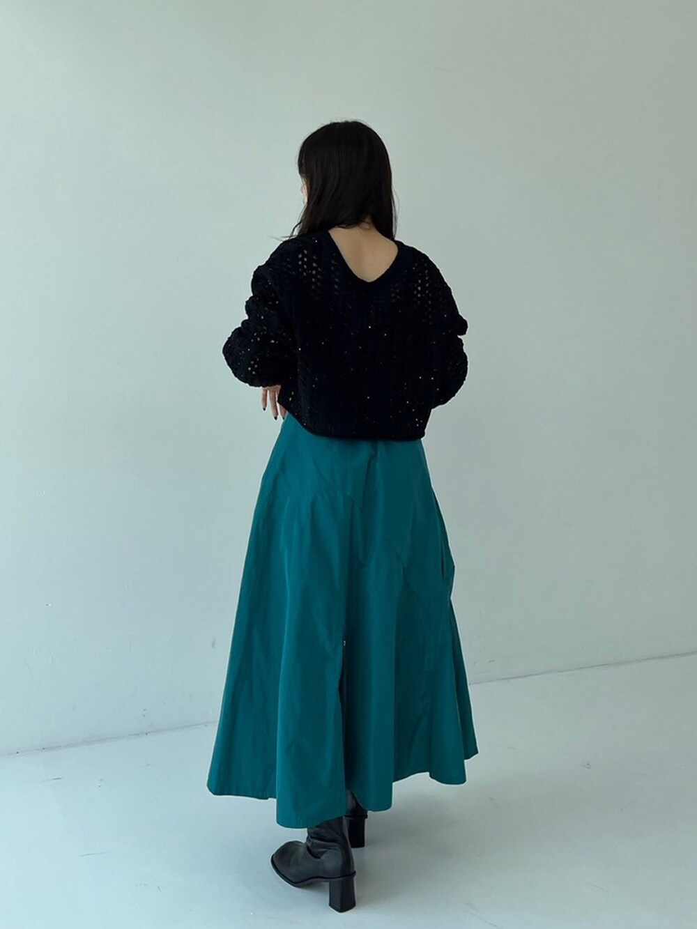 ブラック系のニット/セーター、グリーン系のスカートを着用したレディースの秋コーディネートの3枚目の写真