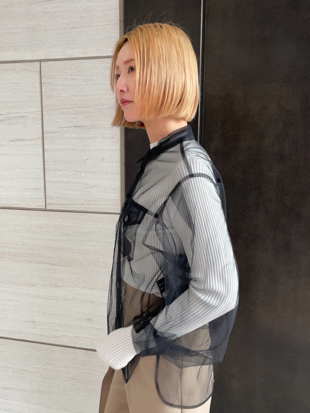 ブラック系のシャツ/ブラウス、ホワイト系のニット/セーター、ベージュ系のその他パンツを着用したレディースの春コーディネートの6枚目の写真