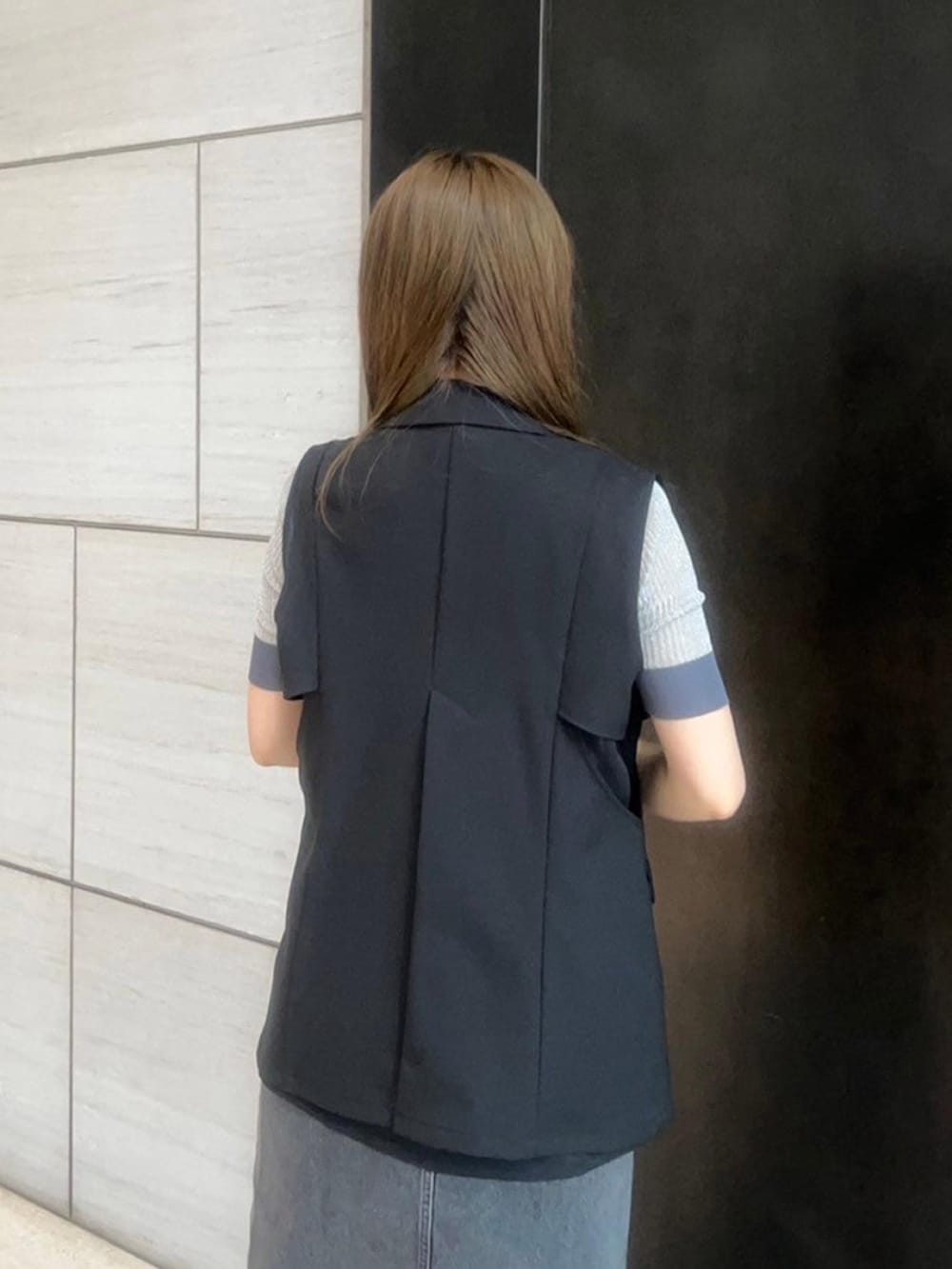 ブラック系のベストを着用したレディースの春コーディネートの6枚目の写真