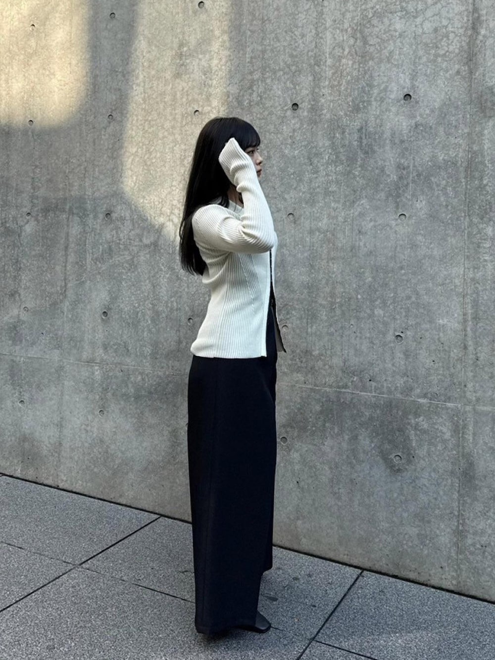 ホワイト系のニット/セーター、ブラック系のその他パンツを着用したレディースの秋コーディネートの2枚目の写真