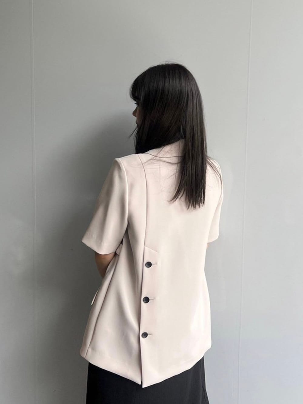 ベージュ系のテーラードジャケット、ブラック系のワンピースを着用したレディースの春コーディネートの6枚目の写真