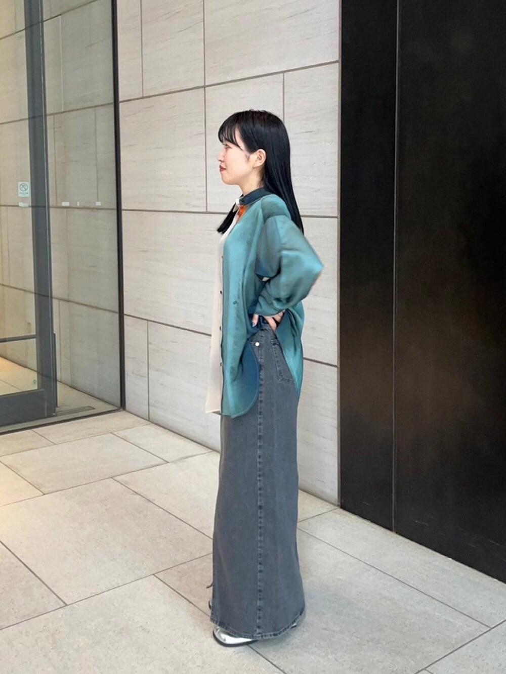 グリーン系のシャツ/ブラウス、ブラック系のデニムスカートを着用したレディースの春コーディネートの2枚目の写真