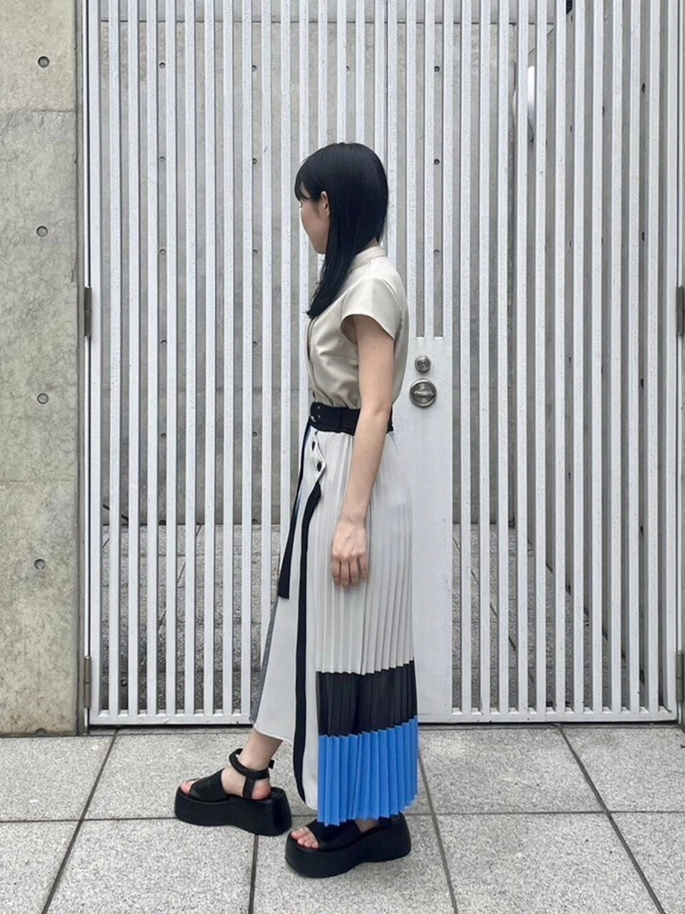 ベージュ系のシャツ/ブラウス、ブルー系のスカートを着用したレディースの春コーディネートの2枚目の写真