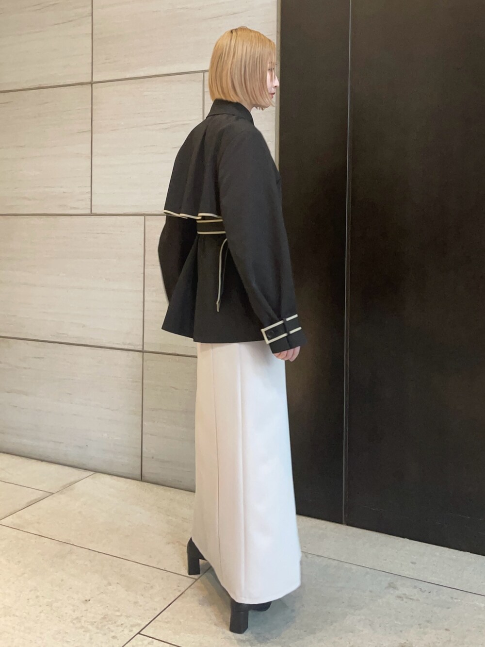 ブラック系のトレンチコートを着用したレディースの春コーディネートの4枚目の写真