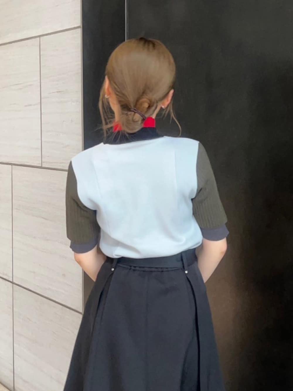 グレー系のニット/セーター、ブラック系のスカートを着用したレディースの春コーディネートの6枚目の写真