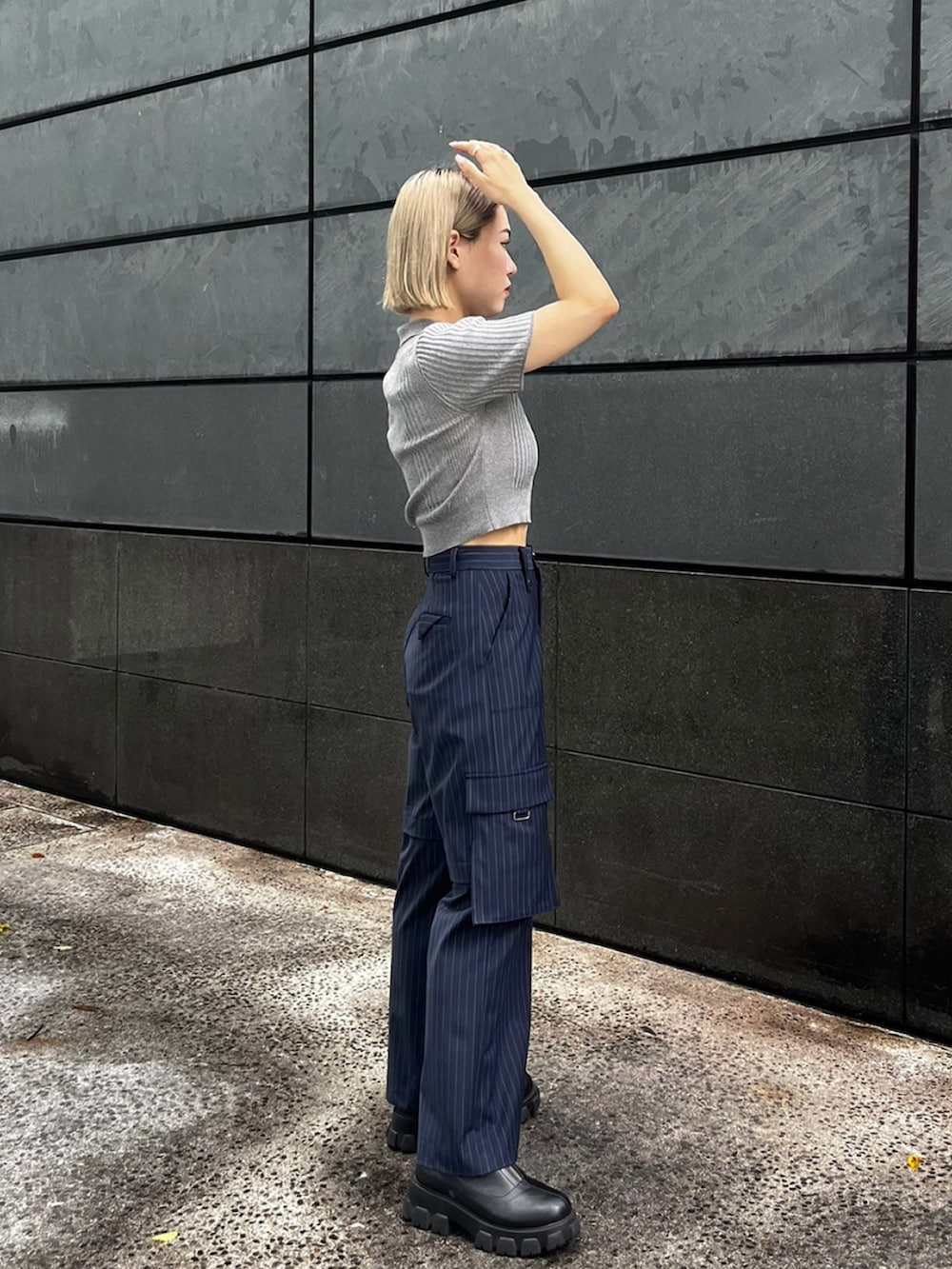 グレー系のポロシャツ、ブルー系のカーゴパンツを着用したレディースの夏コーディネートの2枚目の写真