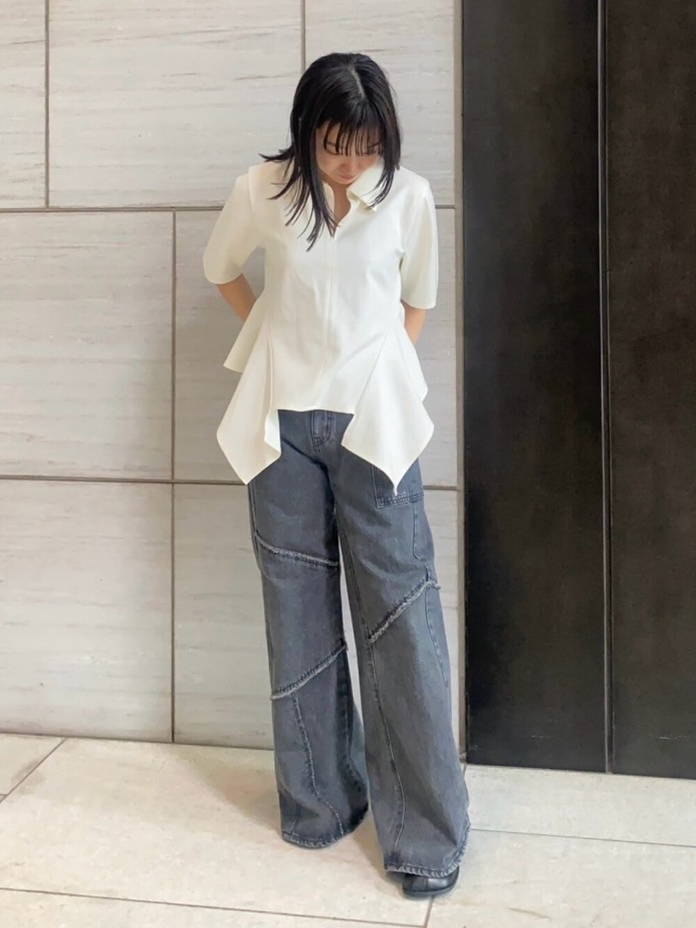 ベージュ系のTシャツ/カットソー、ブラック系のデニムパンツを着用したレディースの春コーディネートの3枚目の写真