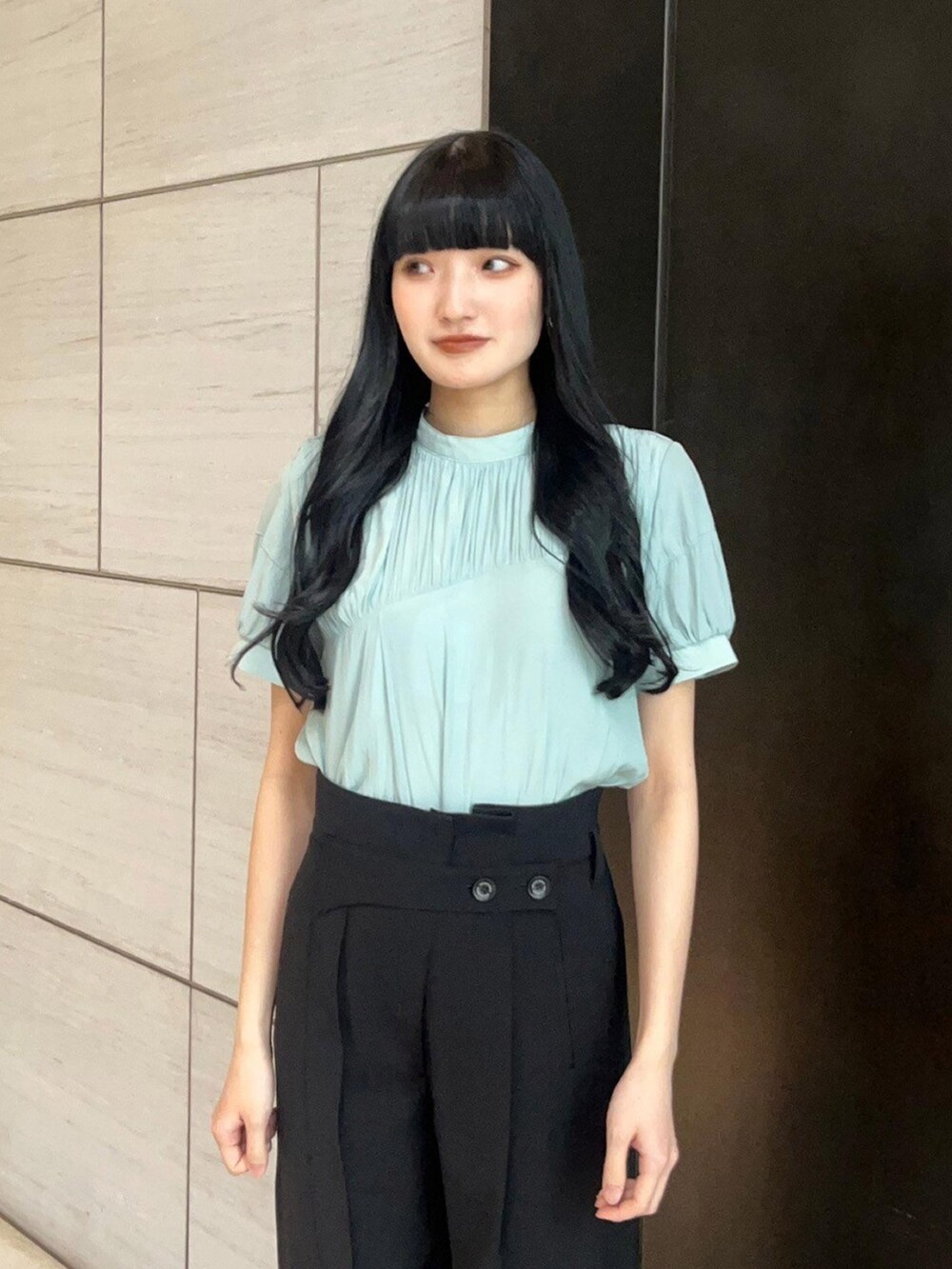 ブラック系のスラックス、グリーン系のシャツ/ブラウスを着用したレディースの春コーディネートの5枚目の写真