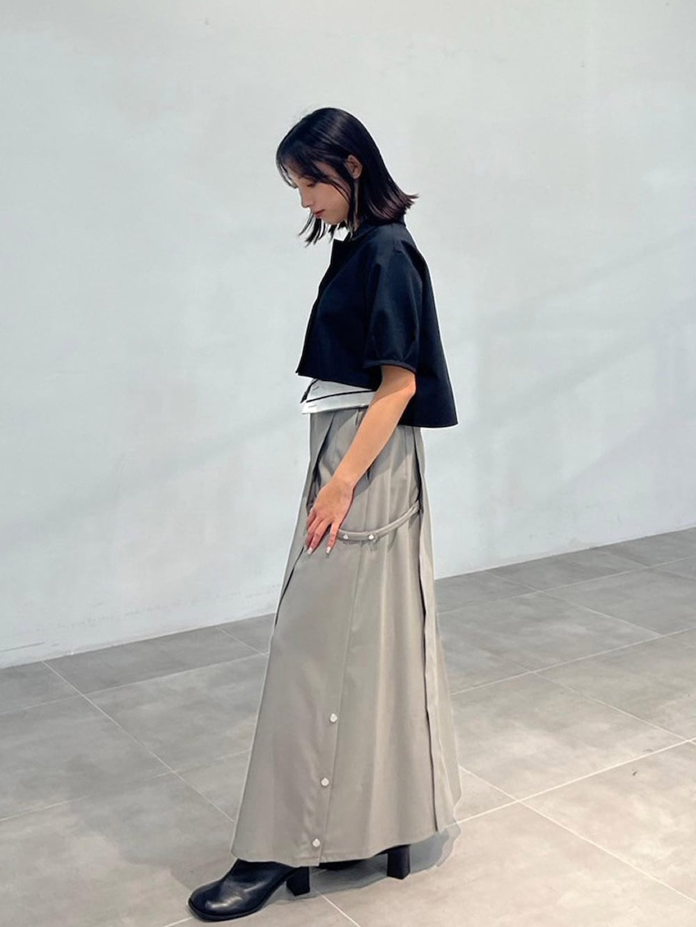 ブラック系のワンピース、グレー系のスカートを着用したレディースの秋コーディネートの2枚目の写真
