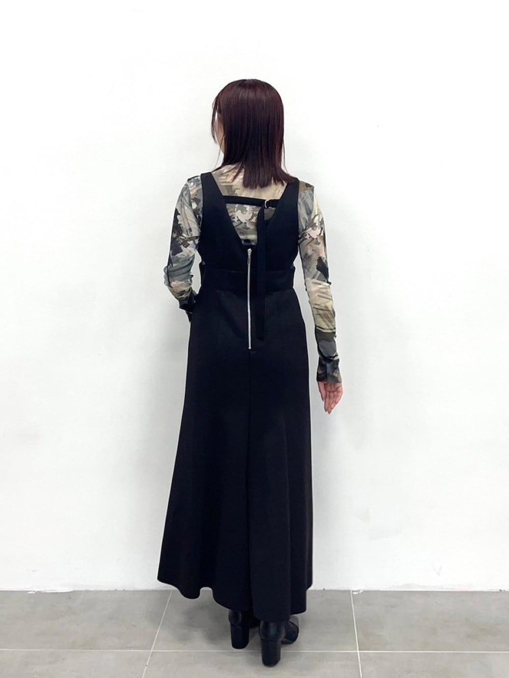 ブラック系のジャンパースカートを着用したレディースの春コーディネートの3枚目の写真