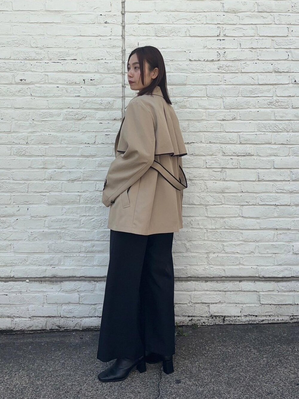 ベージュ系のトレンチコートを着用したレディースの春コーディネートの2枚目の写真