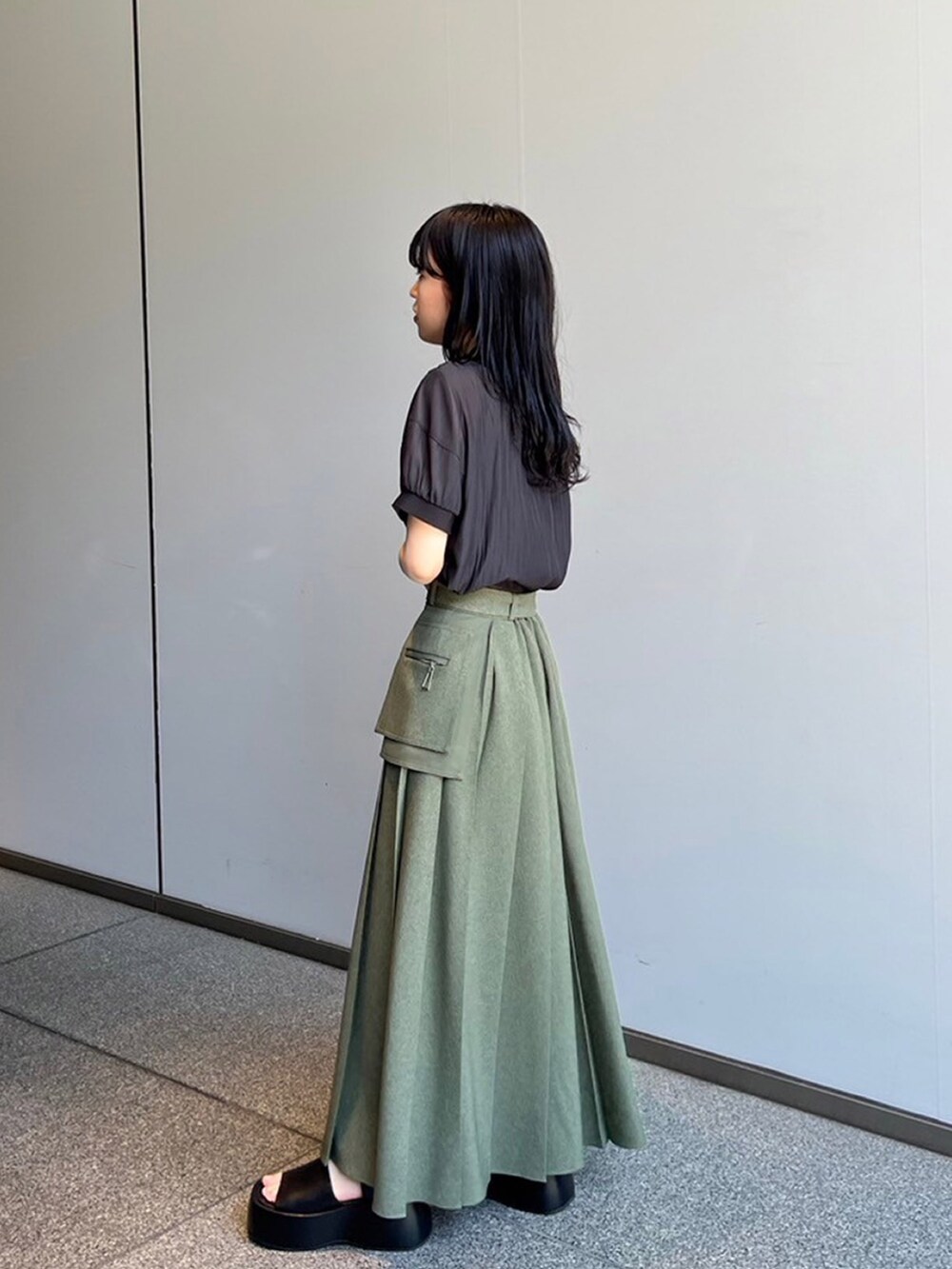 ブラック系のシャツ/ブラウス、グリーン系のスカートを着用したレディースの夏コーディネートの2枚目の写真