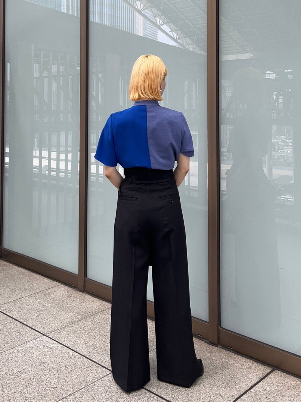 ブルー系のシャツ/ブラウス、ブラック系のスラックスを着用したレディースの夏コーディネートの3枚目の写真