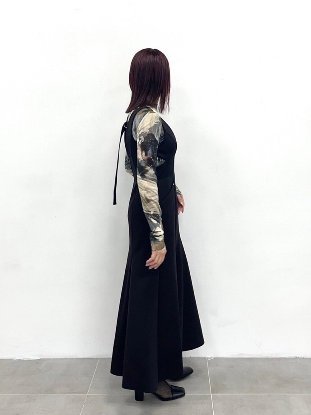 ブラック系のジャンパースカートを着用したレディースの春コーディネートの4枚目の写真