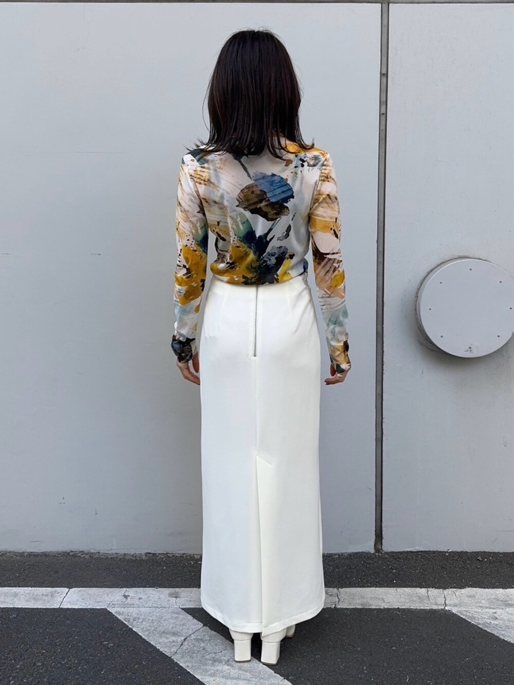 イエロー系のTシャツ/カットソー、ホワイト系のスカートを着用したレディースの冬コーディネートの3枚目の写真