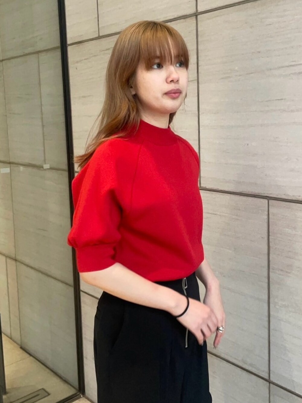 レッド系のニット/セーター、ブラック系のその他パンツを着用したレディースの春コーディネートの4枚目の写真