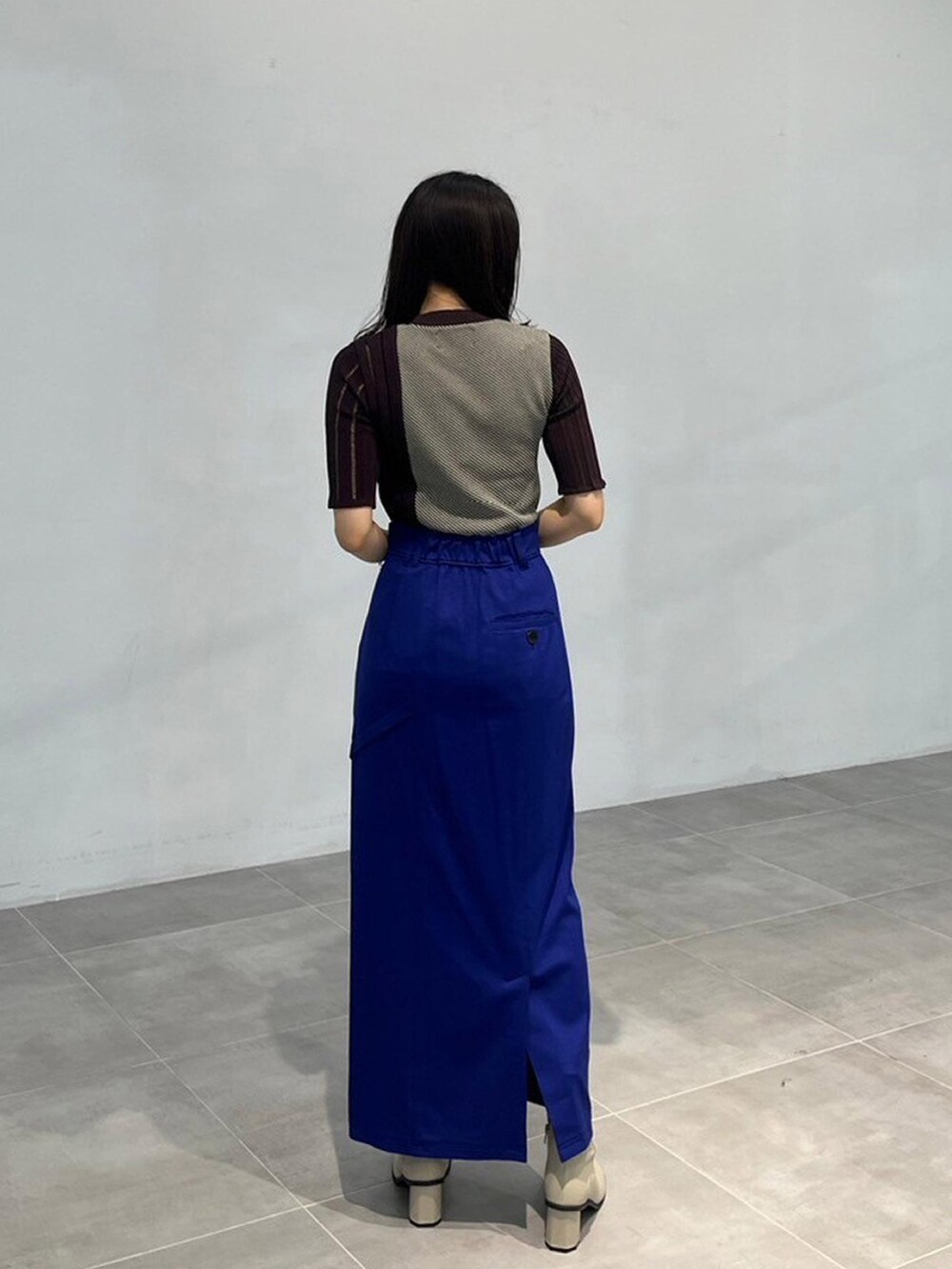 ブラウン系のニット/セーター、ブルー系のスカートを着用したレディースの秋コーディネートの3枚目の写真