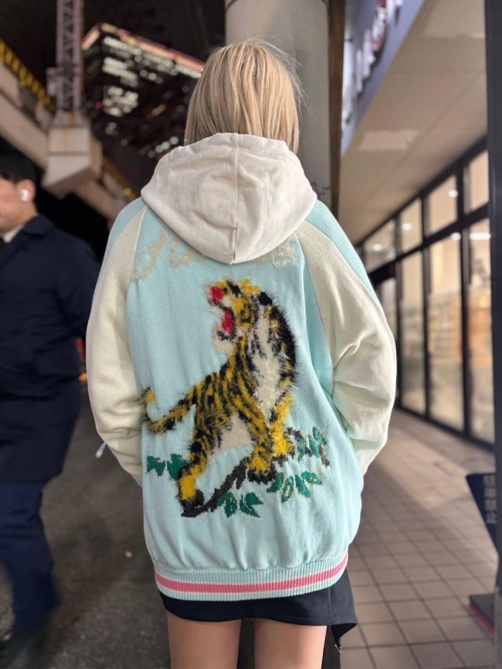 ホワイト系のパーカー、ブルー系のジャケット/アウター、ブラック系のスニーカーを着用したレディースの冬コーディネートの4枚目の写真