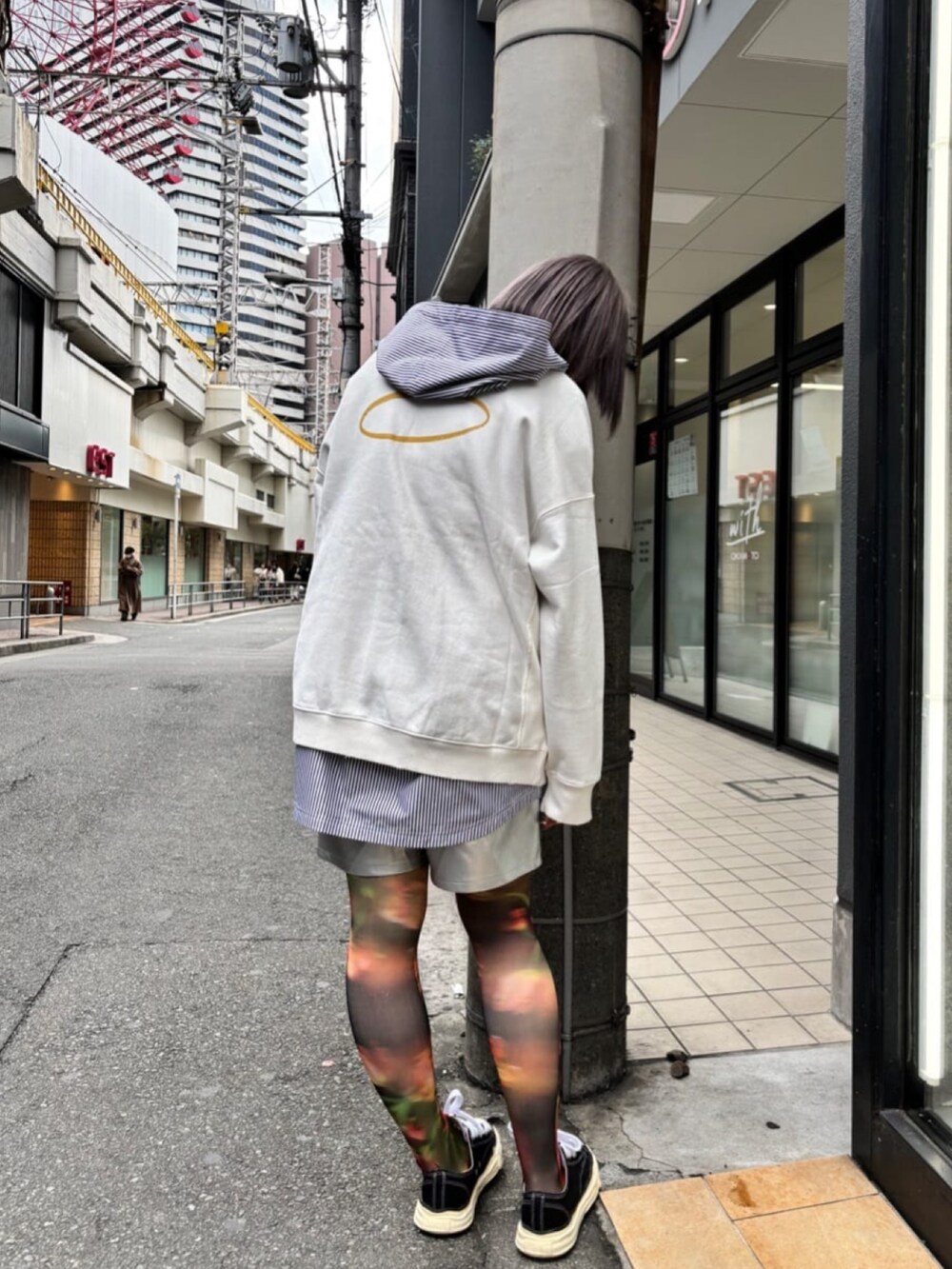 ブラック系のスニーカー、ブルー系のシャツ/ブラウス、ホワイト系のトップスを着用したレディースの春コーディネートの2枚目の写真