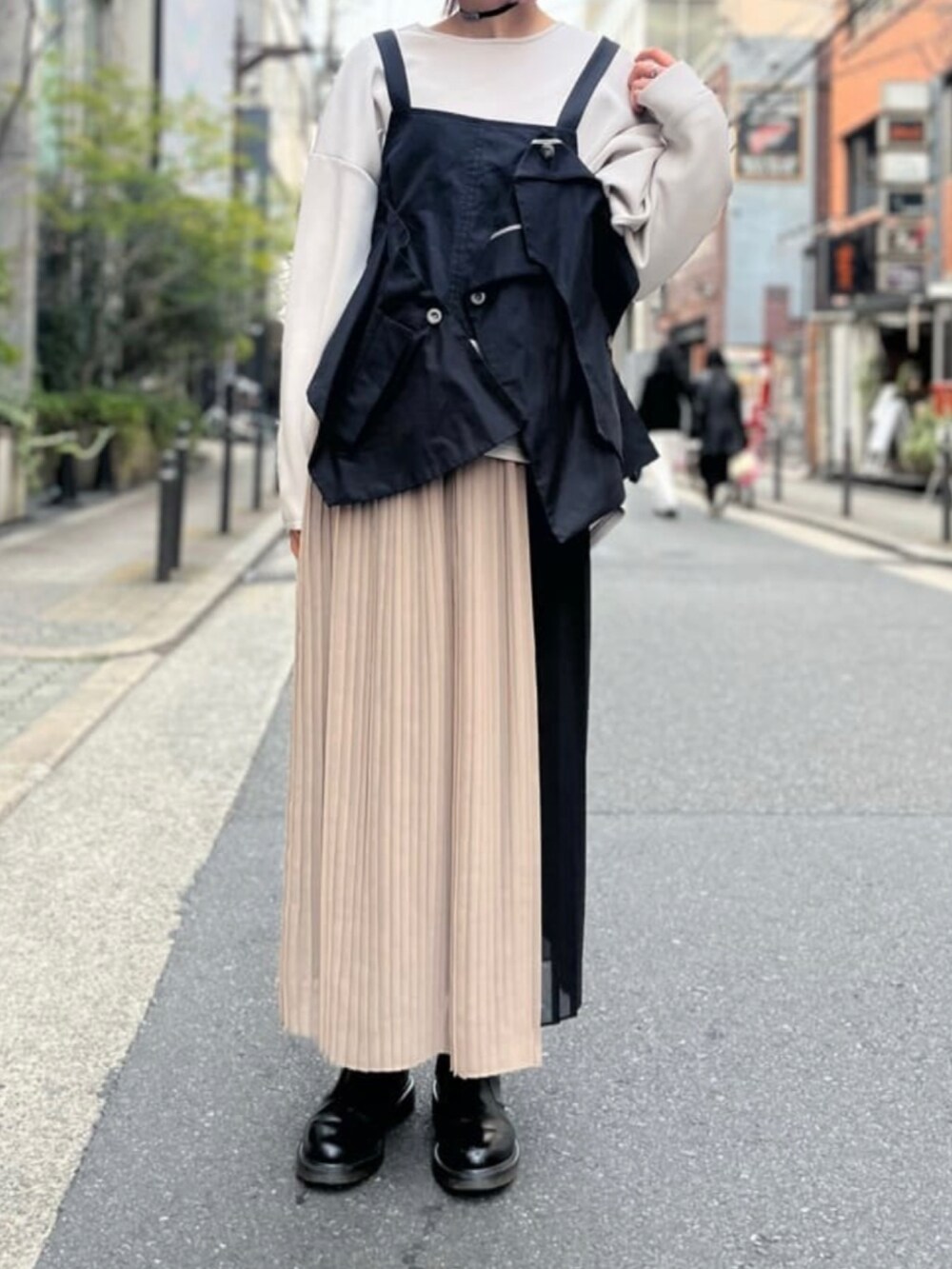 ブラック系のスカート、ブラック系のベスト、グレー系のTシャツ/カットソーを着用したレディースの冬コーディネートの2枚目の写真