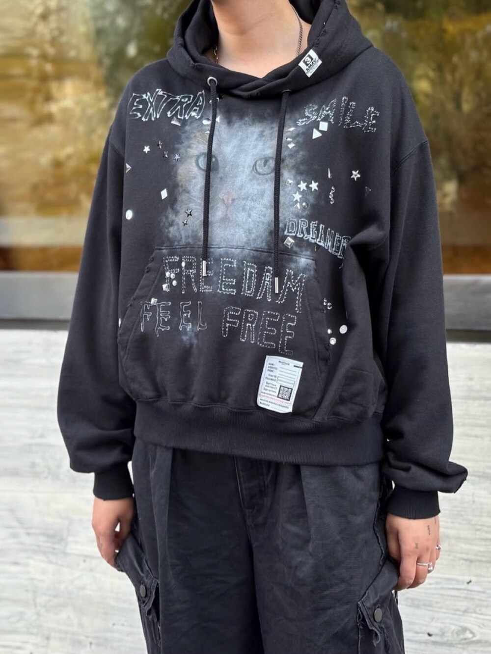 ブラック系のスニーカー、ブラック系のパンツ、ブラック系のパーカーを着用したレディースの秋コーディネートの2枚目の写真